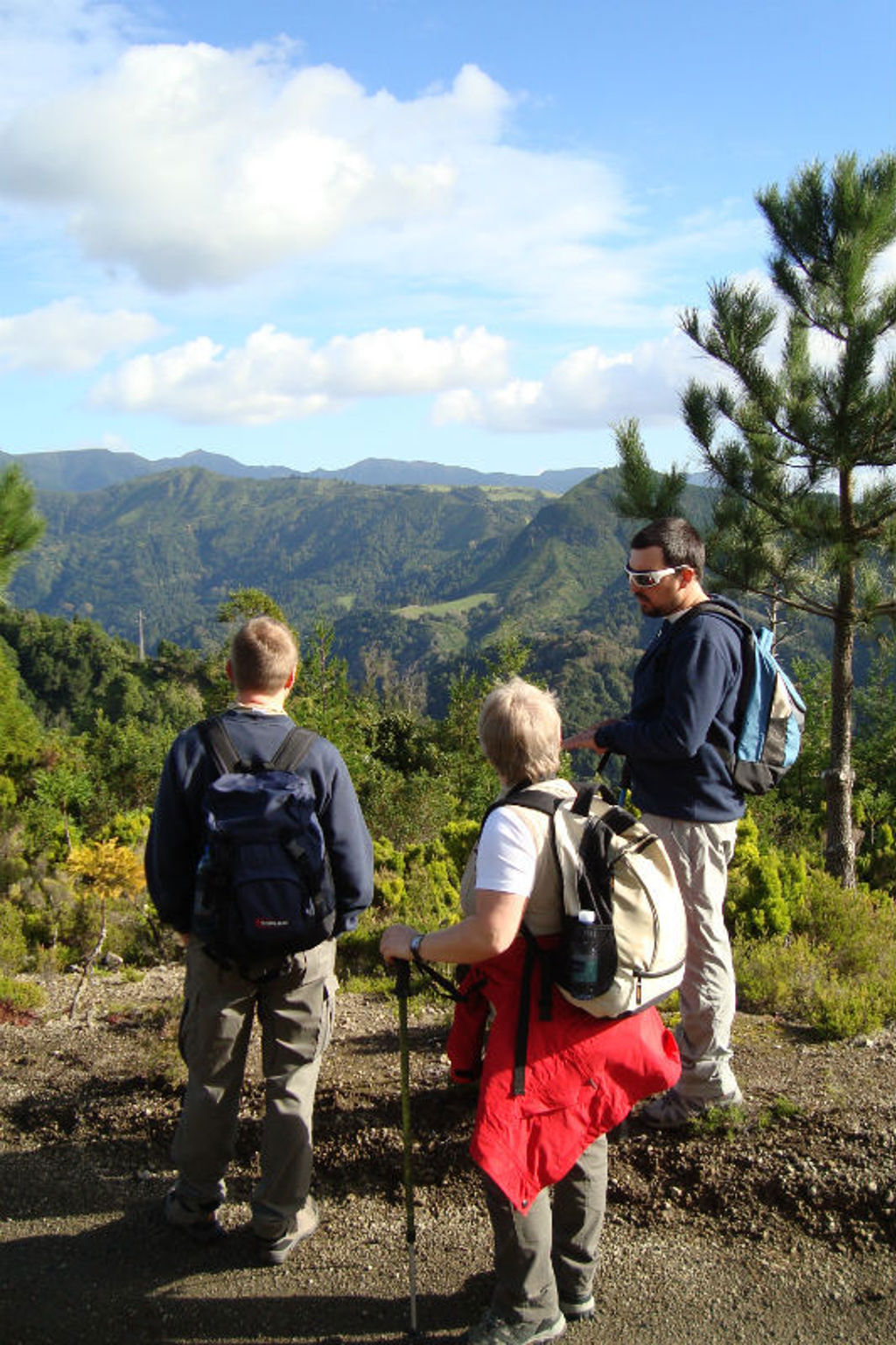 Wandelaars met rugzakken genieten van het uitzicht over de groene bergen van São Miguel op de Azoren.