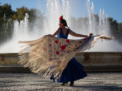 Flamencodanseres met kleurrijke sjaal voor een fontein in Spanje tijdens familiereis Spanje & Portugal.