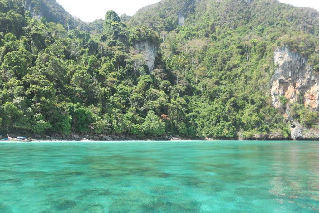 Turquoise zee bij een groen, rotsachtig eiland in Zuid-Thailand tijdens groepsrondreis Thailand Noord en Zuid.