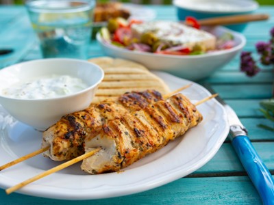 Gegrilde souvlaki met tzatziki en Griekse salade op een tafel in Noord-Griekenland.