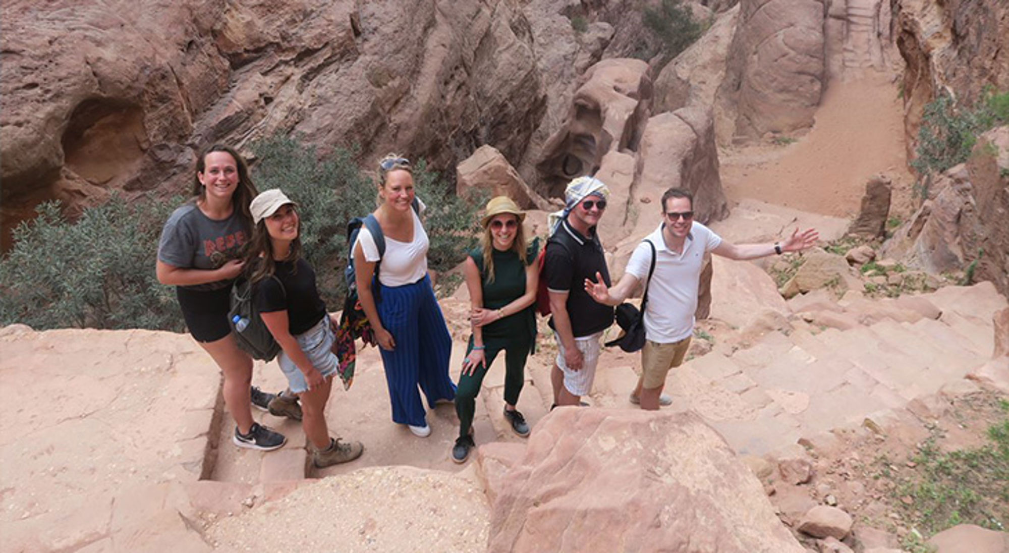 Petra Jordanië Groep reizigers op rotsachtige trappen in een kloof tijdens een wandeling.