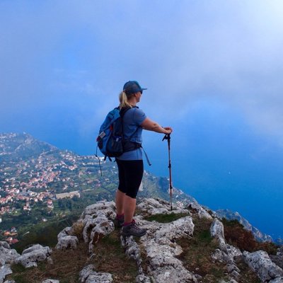 Wandelaar met rugzak en wandelstokken op een pad aan de Amalfikust, Italië.