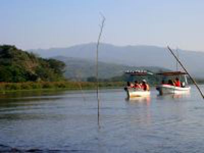 Boottocht op Lake Naivasha tijdens Route Kenia, met twee boten op het water en bergen op de achtergrond.