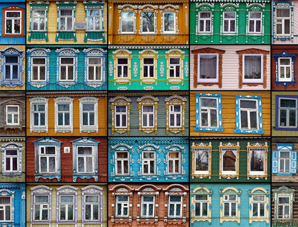 Gekleurde houten huizen met rijk versierde raamkozijnen in Rusland, tijdens de winterrondreis.