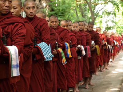 Boeddhistische monniken in rode gewaden staan in een rij tijdens de Myanmar rondreis van 25 dagen.