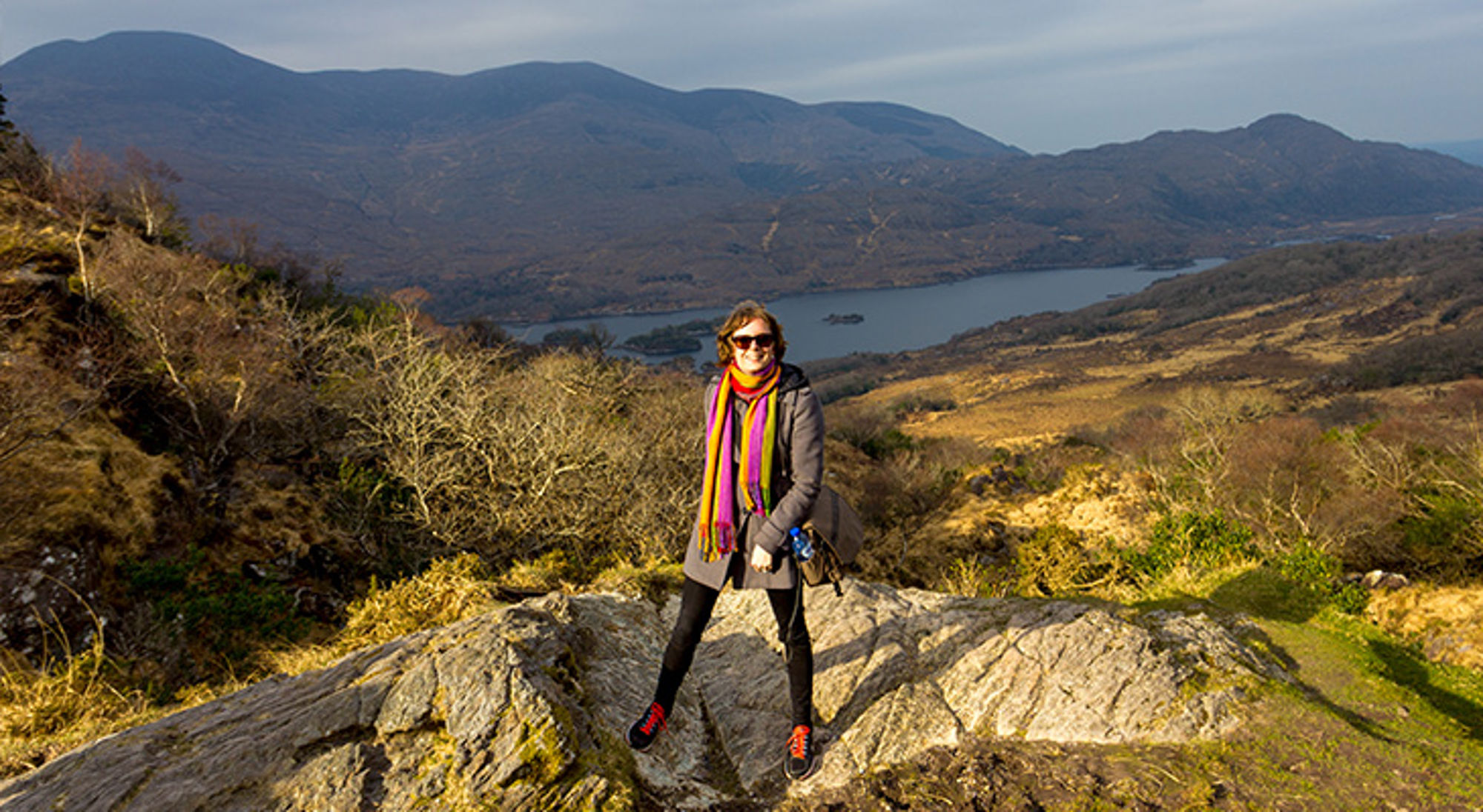 Ring of Kerry, Ierland Wandelaar op rots met uitzicht op een meer en bergen tijdens een hike.