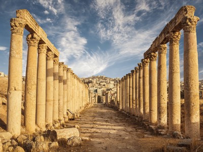 Romeinse zuilengang in Jerash, Jordanië, met uitzicht op de stad in de verte.