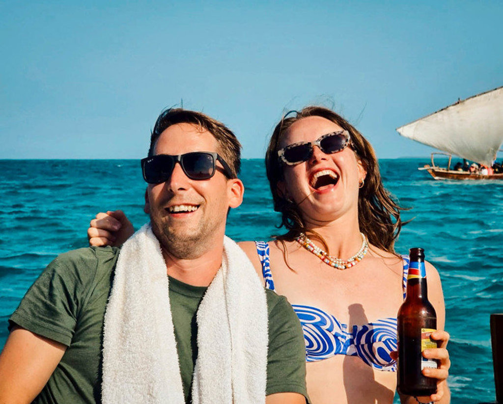 Jonge reizigers lachen op een boot op zee tijdens 22-35ers reis Kenia & Tanzania.