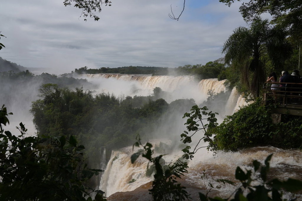 Uitzicht op de Iguazú-watervallen in Argentinië, met nevel boven de jungle en een uitkijkplatform.