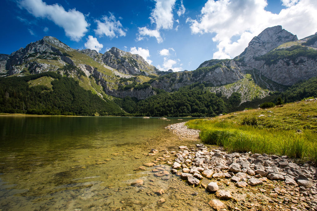 Berglandschap met helder bergmeer en rotsachtige oever tijdens rondreis Montenegro.