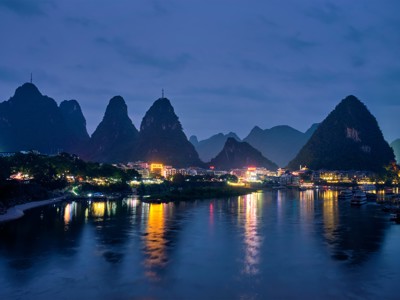 Avondzicht op Guilin met karstbergen en stadslichten die weerspiegelen in de Li-rivier.
