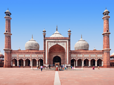 Jama Masjid-moskee in Delhi met rode zandsteen, witte koepels en minaretten onder een heldere blauwe lucht.
