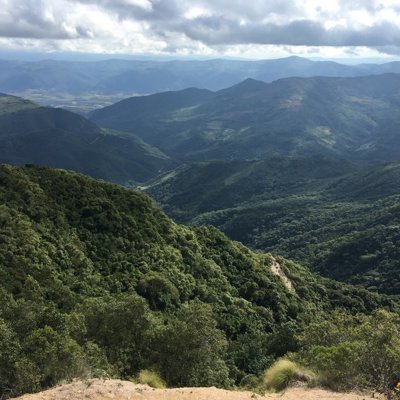 Groene bergvallei met nevel en wolken boven de Andes tijdens groepsrondreis Bolivia en Chili.