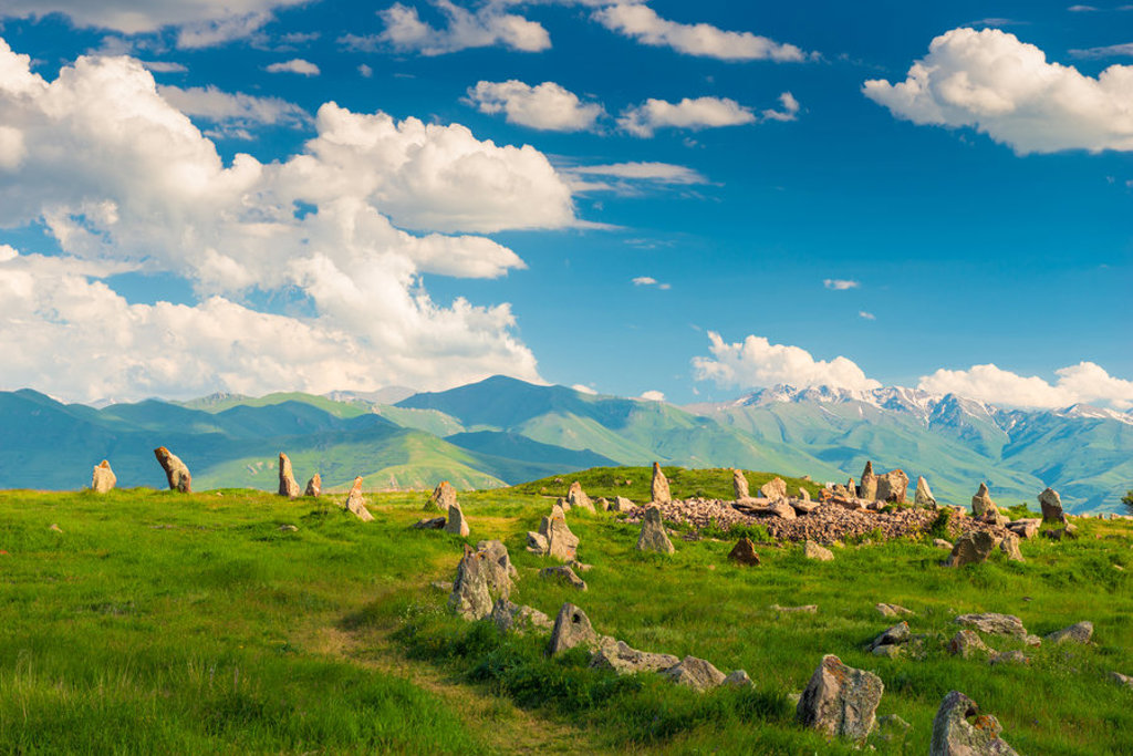 Groene bergweide met stenen en panoramisch uitzicht op het Kaukasusgebergte in Armenië en Georgië.