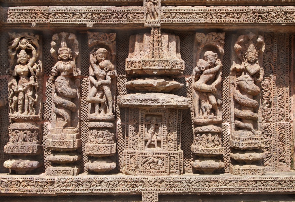 Gedetailleerde reliëfs op een tempelmuur in Orissa, India, met figuren en sierlijke steenornamenten.