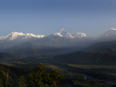 Panorama van de besneeuwde Himalaya met bergdorpen en rivierdal in Nepal.