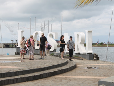 Toeristen bij de grote witte letters “LOSARI” aan de boulevard van Makassar op Sulawesi.
