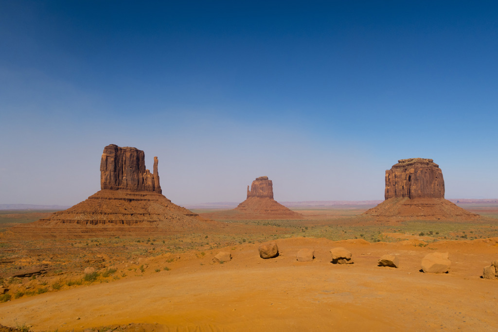 Monument Valley in de Verenigde Staten met rode rotsformaties in de woestijn onder een blauwe lucht.