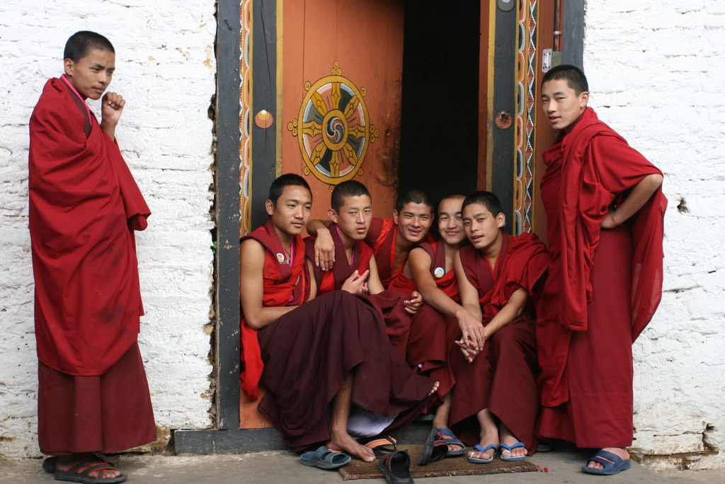 Monniken in rode gewaden bij de ingang van een boeddhistisch klooster tijdens groepsrondreis Sikkim en Bhutan.