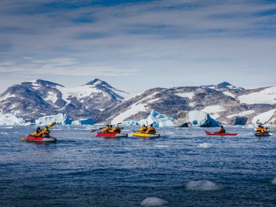 Kajakkers tussen drijvende ijsschotsen langs de kust van Groenland tijdens de route Canada en Groenland, 18 dagen.