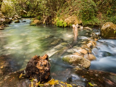 Heldere bergbeek met rotsen en groen langs de wandelroute in Andalusië, Spanje.