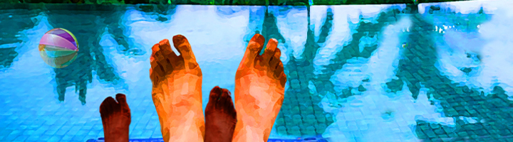 Voeten van een volwassene en een kind aan de rand van een zwembad, met een strandbal in het water.