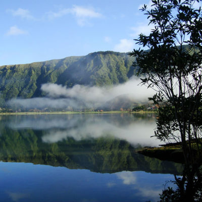 Groen berglandschap met mist boven een kratermeer op São Miguel, Azoren.