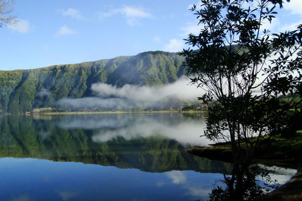 Groen berglandschap met mist boven een kratermeer op São Miguel, Azoren.