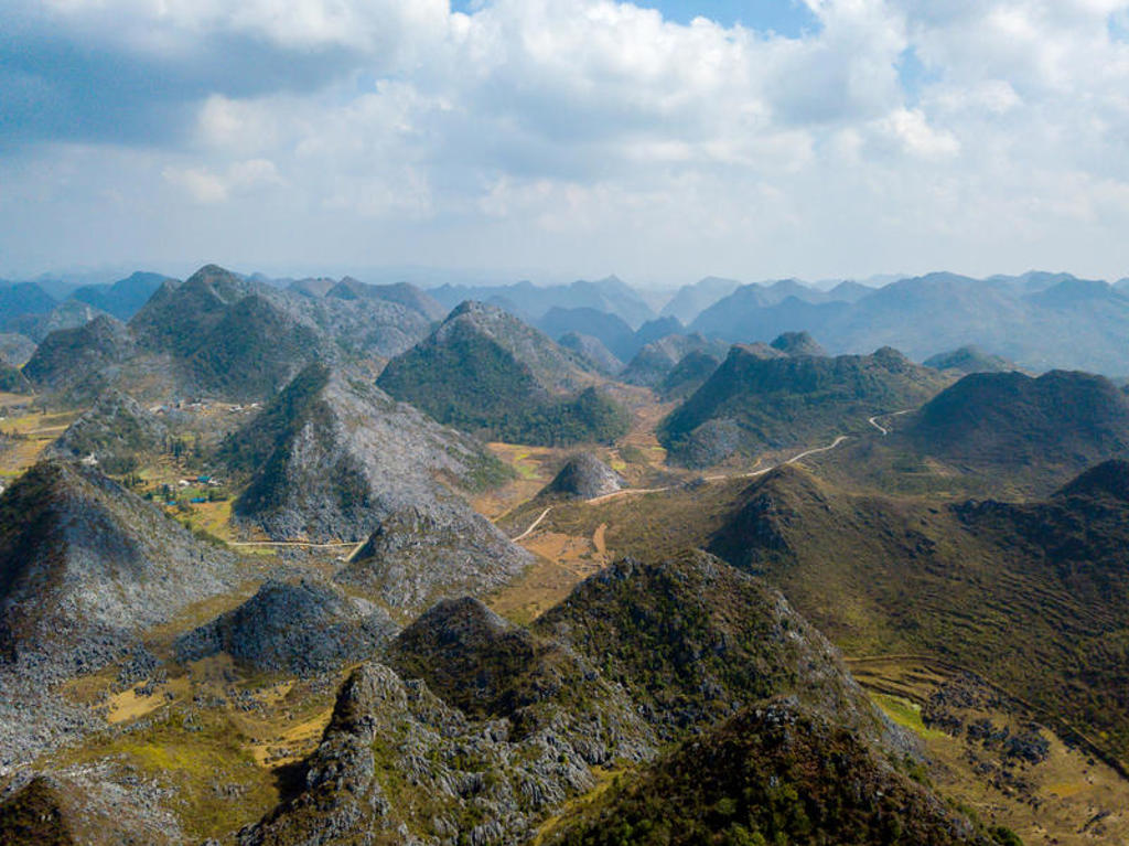Karstlandschap met kalkstenen heuvels en kronkelende wegen in China, tijdens groepsrondreis China & Vietnam.