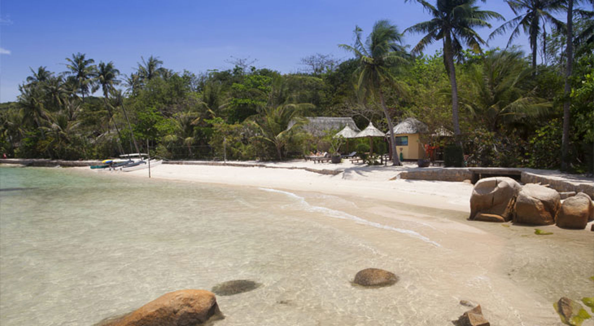 Strand Nha Trang Tropisch zandstrand in Vietnam met palmbomen, helder zeewater en strandhuisjes aan de kust.