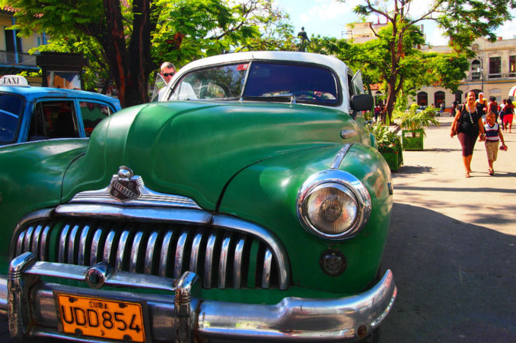 Groene klassieke auto op straat in Cuba tijdens groepsrondreis met Casas Particulares.