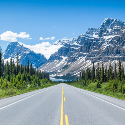 Weg door de Canadese Rockies met besneeuwde bergtoppen en naaldbos, Canada West familiereis.