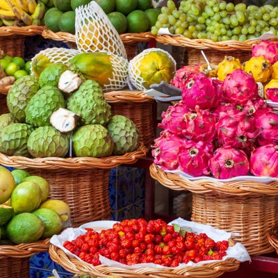 Fruitmarkt in Funchal met kleurrijke exotische vruchten zoals pitaya, cherimoya, druiven en citrus.