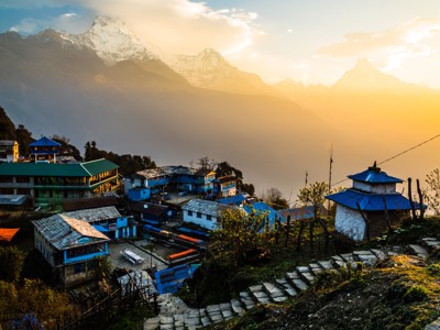 Dorp in de Annapurna-regio met bergpanorama bij zonsopkomst tijdens de Route Nepal Annapurna-trektocht.
