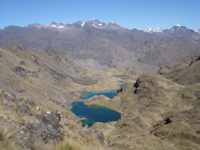 Berglandschap in Peru met turquoise bergmeren en besneeuwde toppen onder een heldere blauwe lucht.
