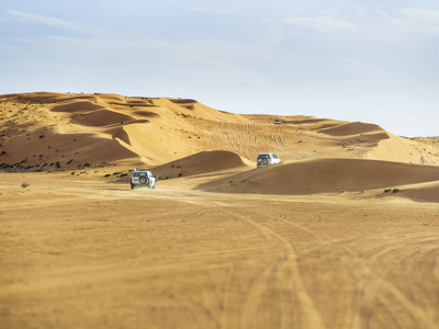 4x4-jeeps rijden door zandduinen in de woestijn van Oman tijdens de route Oman en Dubai, 11 dagen.