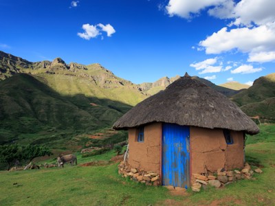 Ronde hut met rieten dak in het berglandschap van Lesotho op de route Johannesburg - Kaapstad.