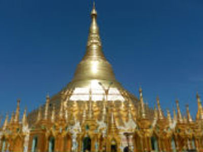 Gouden Shwedagon Pagode in Yangon, Myanmar, met glanzende stupa tegen een blauwe lucht.