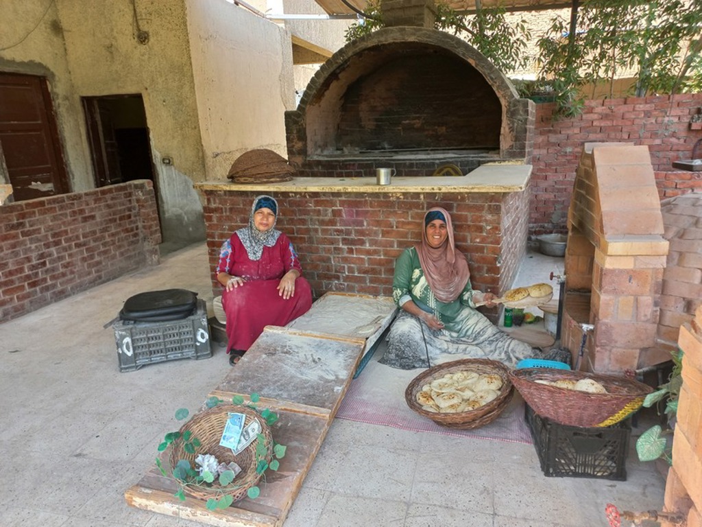 Vrouwen bakken traditioneel brood bij een steenoven tijdens een groepsrondreis door Egypte.