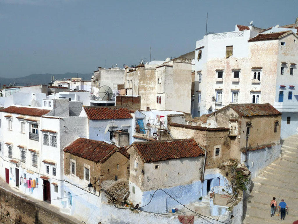 Witte en blauw geschilderde huizen met rode daken in Chefchaouen, Marokko.