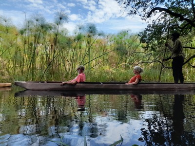Mokorotocht met gids en reizigers door de Okavango Delta, langs riet en papyrus.