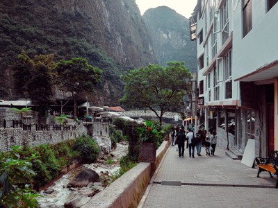 Straat in Aguas Calientes met rivier en bergwanden, op route Peru naar Machu Picchu.
