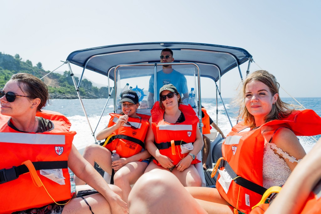 Jonge reizigers met reddingsvesten op een boottocht langs de Albanese kust tijdens een 22-35ers reis Albanië.