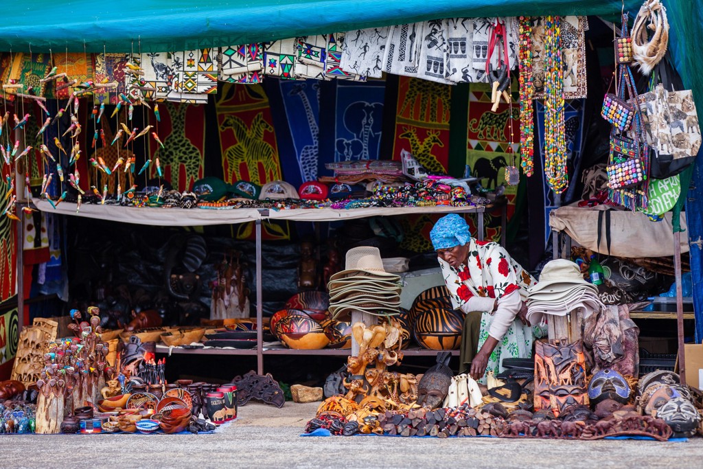 Marktkraam met kleurrijke Afrikaanse kunst en souvenirs tijdens groepsrondreis Zuid-Afrika, eSwatini en Lesotho.
