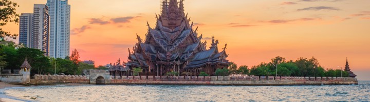 Sanctuary of Truth-tempel aan zee bij Pattaya tijdens zonsondergang.