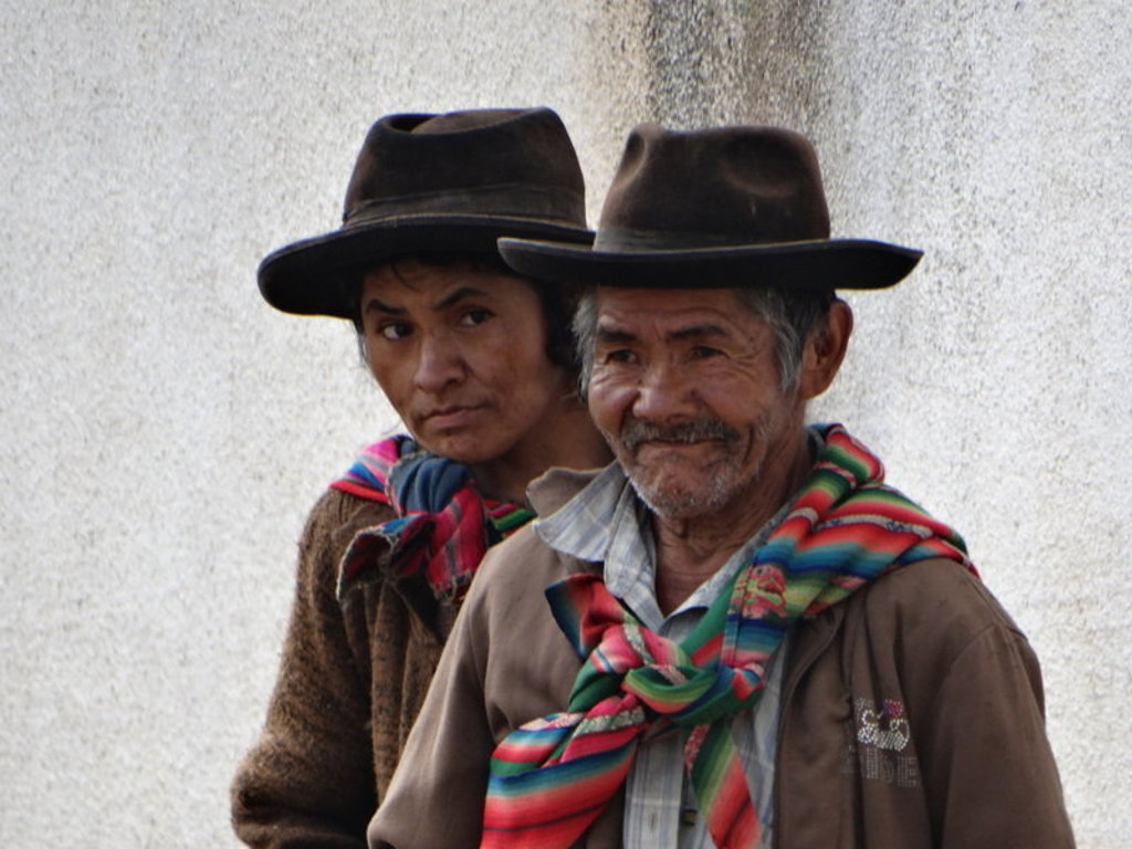 Twee mannen met hoeden en kleurrijke sjaals in Bolivia tijdens een groepsrondreis Bolivia en Chili.