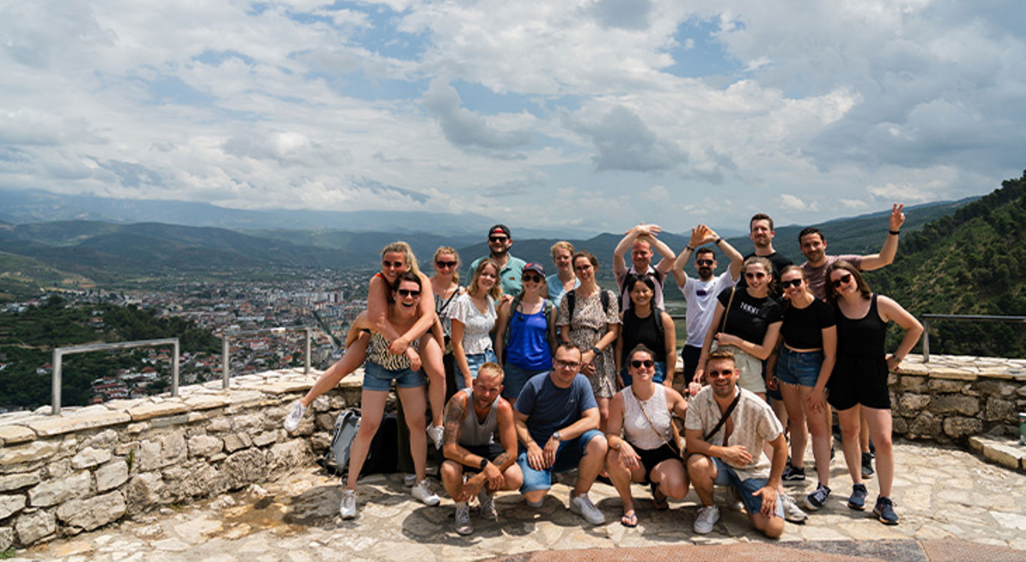 Berat Albanië Groepsfoto van reizigers bij een uitzichtpunt met panorama over de stad en bergen.