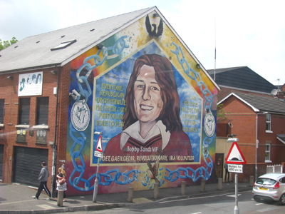 Muurschildering van Bobby Sands op een gevel in Belfast, Noord-Ierland.