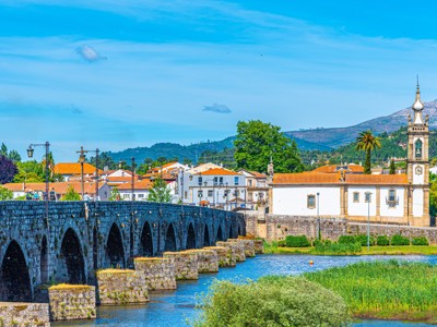 Stenen boogbrug over de rivier met kerk en dorp in Portugal tijdens familiereis Spanje & Portugal.