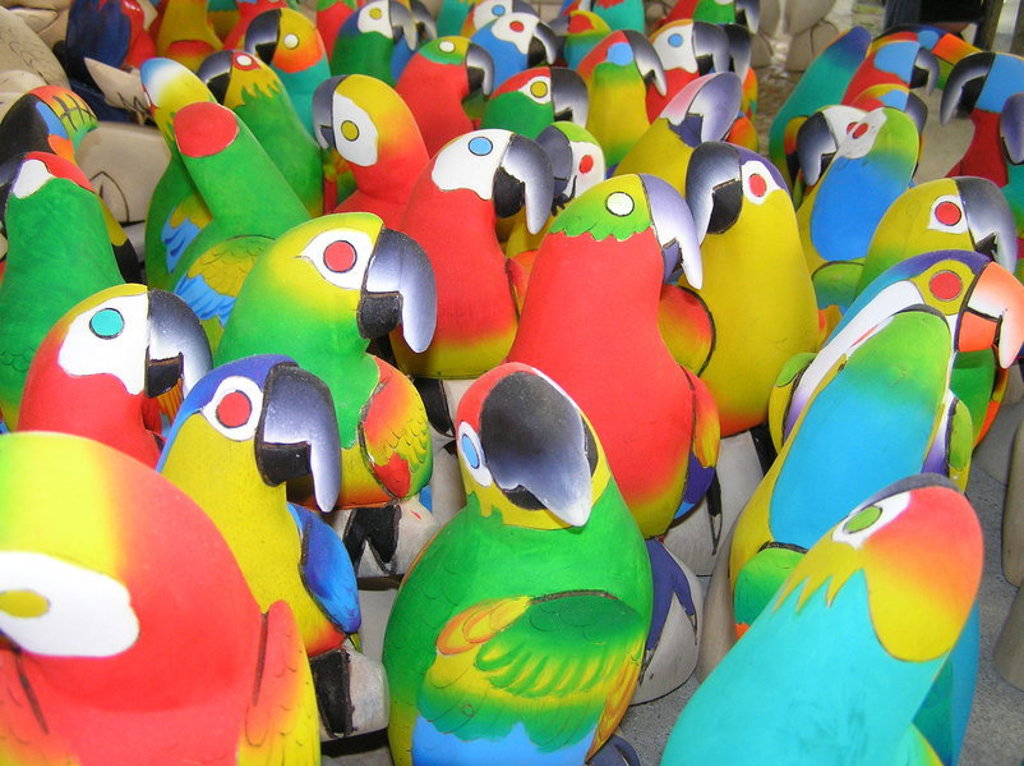 Kleurrijke papegaaienbeelden op een markt in Ecuador tijdens een familiereis.